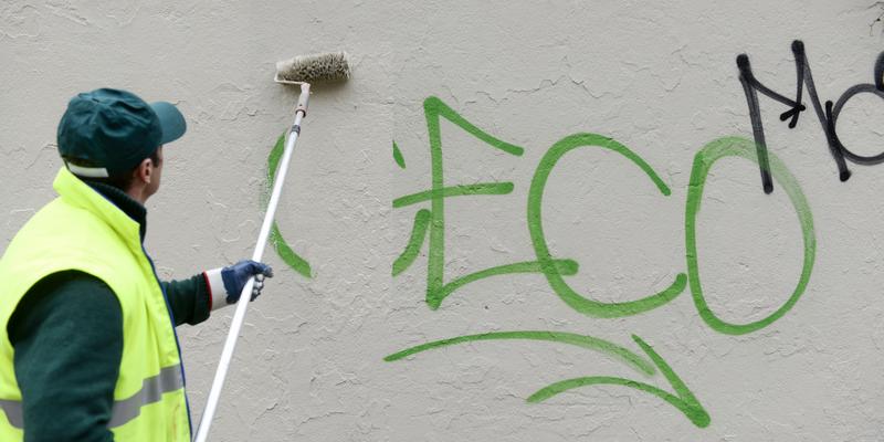 G & M employee painting over graffiti
